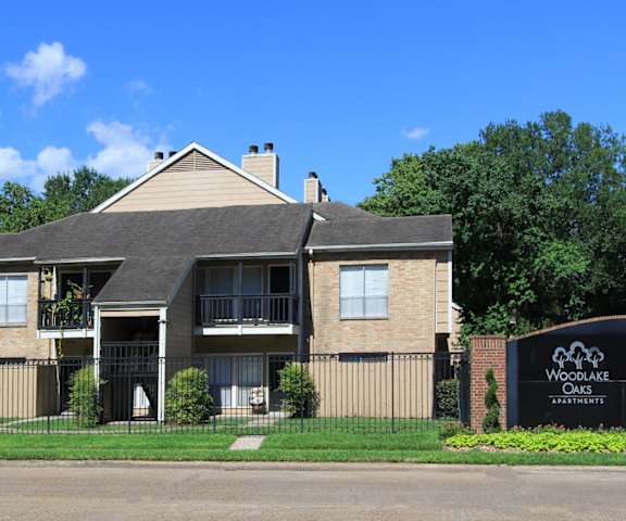 a large brick house with a black wrought iron fence