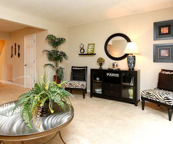 a living room with a round coffee table in the middle of the room