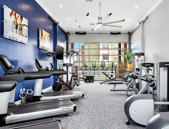 a gym with exercise equipment and a large window