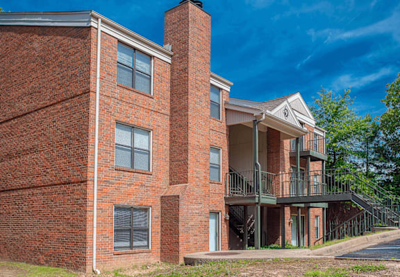 a brick building with a balcony and a blue sky
