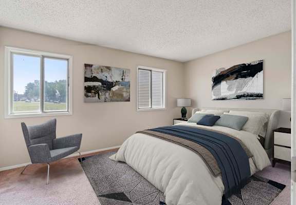 a bedroom with a bed and a chair in front of a window