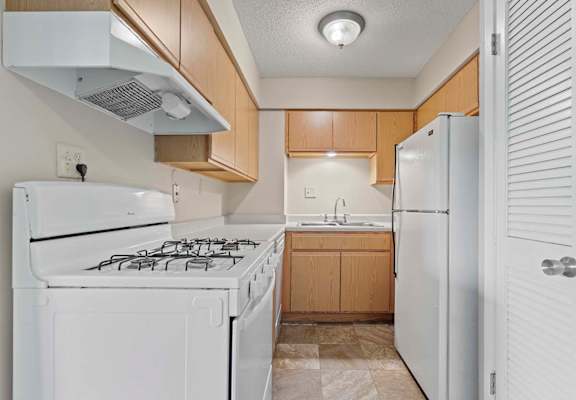 a kitchen with white appliances and wooden cabinets