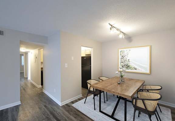 A dining room with a wooden table and chairs.