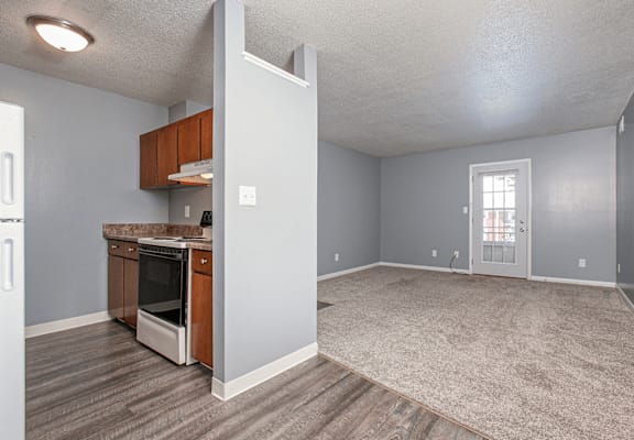 A kitchen with a refrigerator, oven, and cabinets.