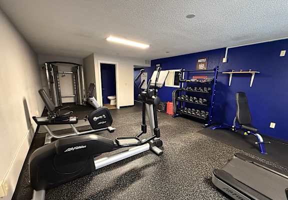 A gym with treadmills, weights, and exercise equipment.