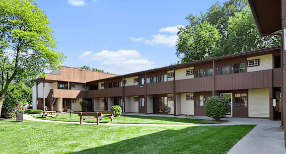 a building with a yard and a bench in front of it