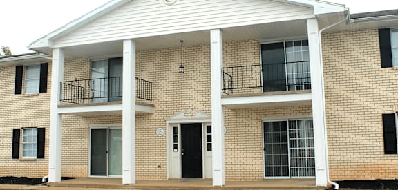 a building with a black door and two balconies