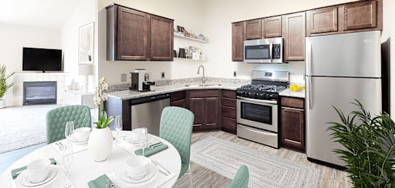 a kitchen with stainless steel appliances and a dining table