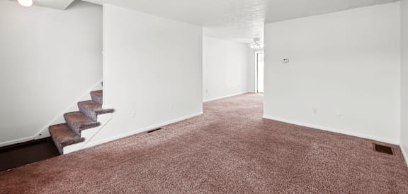 A room with a staircase and carpeted floor.