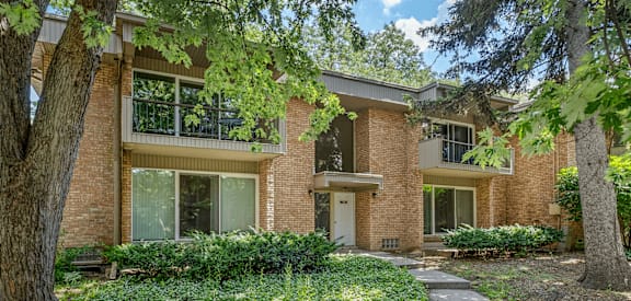 A brick house with a green lawn in front.