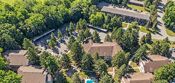A bird's eye view of a residential area with houses and a swimming pool.
