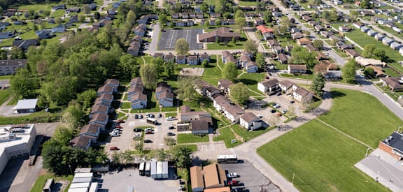 A bird's eye view of a residential area with houses and parked cars.
