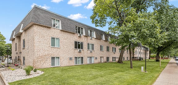 a large brick building with a grassy area in front of it