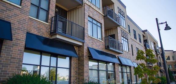 a brick apartment building with black awnings
