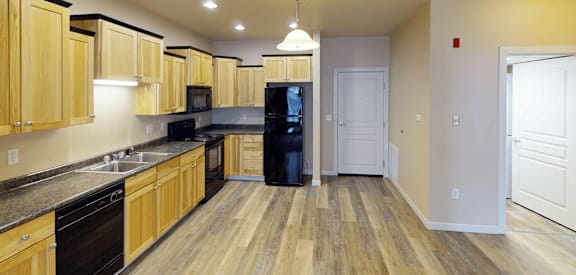 a kitchen with wooden cabinets and black appliances