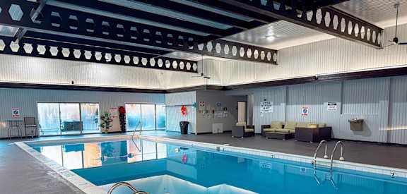 A large indoor swimming pool with a diving board.