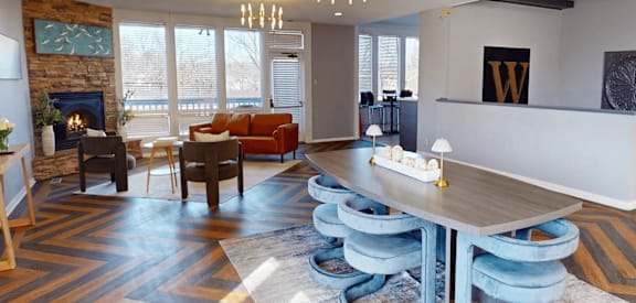 A modern living room with a stone fireplace and a large wooden table.