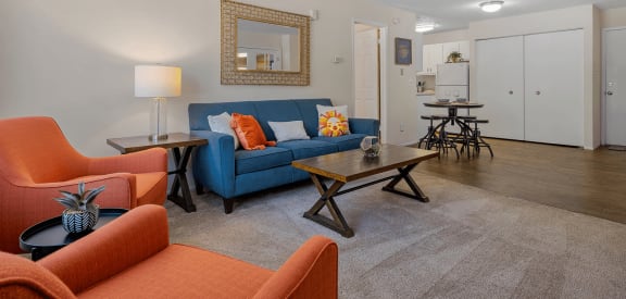 a living room with a blue couch and orange chairs