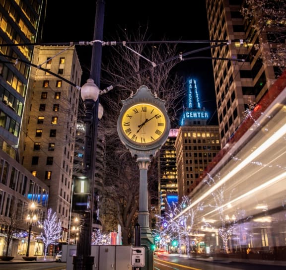 a clock in the middle of a city street at night