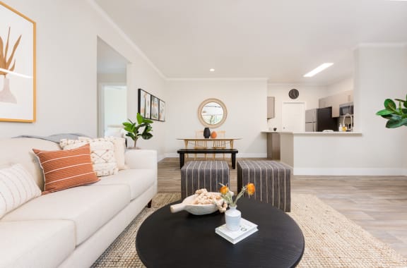 a living room with a couch table and a kitchen in the background