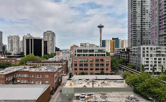 A cityscape with a large building in the foreground and a tower in the background. at The Windham Apartments, Washington, 98121