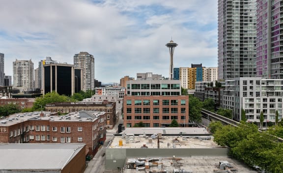 A cityscape with a large building in the foreground and a tower in the background. at The Windham Apartments, Washington, 98121
