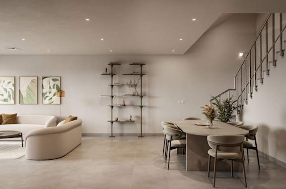 A modern dining room with a white table and chairs.