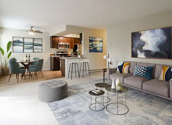 a living room with a couch and a table in front of a kitchen