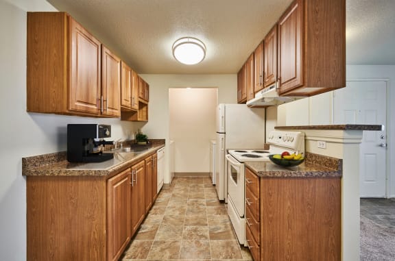 Kitchen with wooden cabinets and white appliances at Brookside 112, WA, 98682