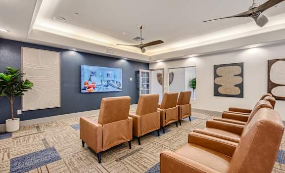 a conference room with leather chairs and a wall mounted tv