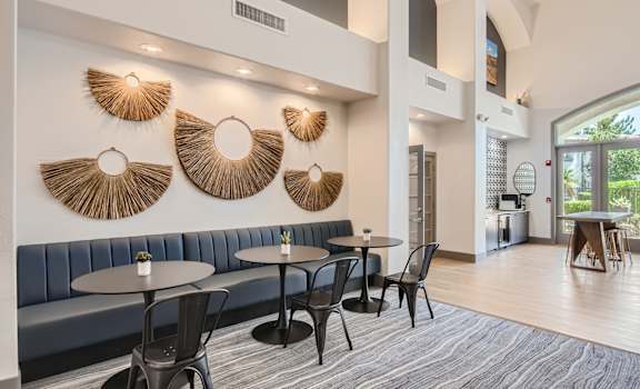 a lobby with tables and chairs and a large window