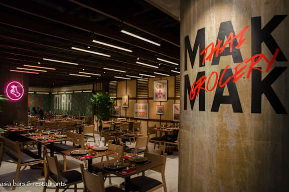 A restaurant with tables and chairs and a sign that says Makro.