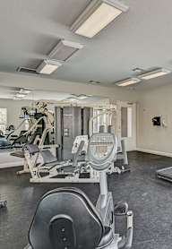 A spacious gym with treadmills, elliptical machines, and weight machines.