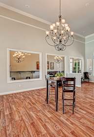 A dining room with a wooden floor and a chandelier.