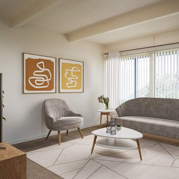 A living room with a grey couch, a grey armchair, a white coffee table, and two framed artworks on the wall.
