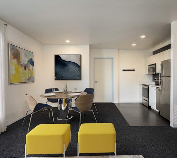 A modern kitchen with a dining table and chairs.