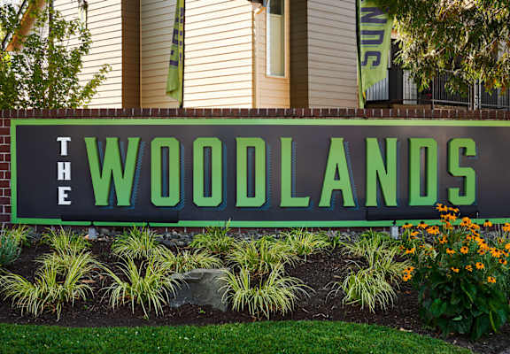 a sign in front of a house that says the woodlands