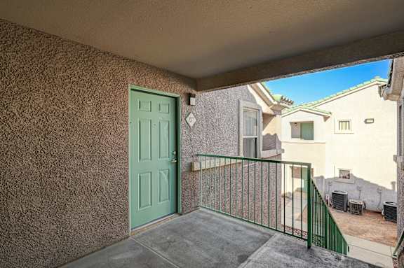 A balcony with a green door and a green railing.