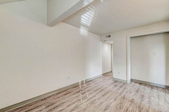 A room with a light wood floor and white walls.