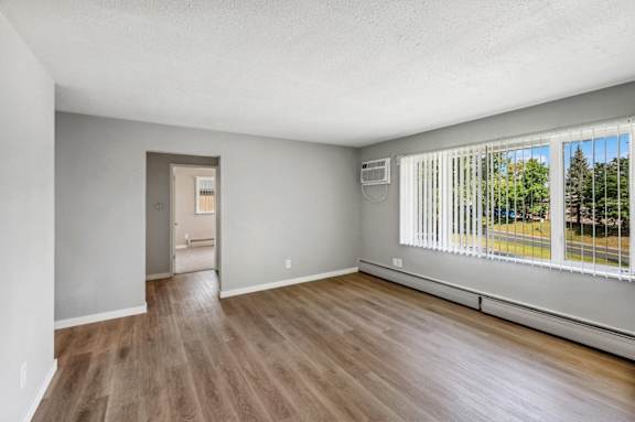 an empty living room with wood floors and a large window