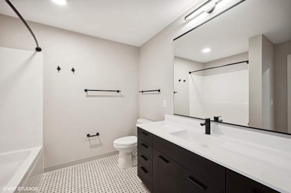 a bathroom with a large mirror and a sink and a toilet