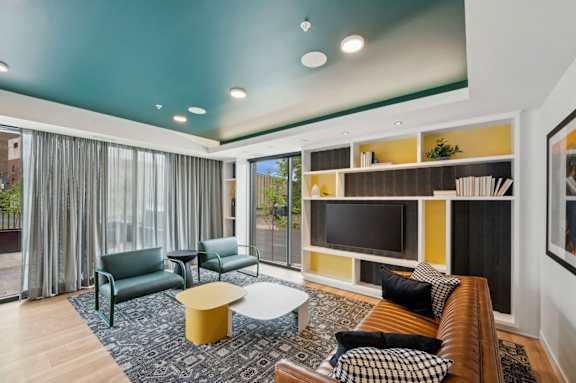 a living room with a couch and chairs and a television