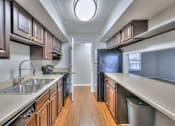 Thumbnail 1 of 28 - A kitchen with brown cabinets and a white sink at Landmark at Lyncrest Reserve Apartments, Nashville, TN