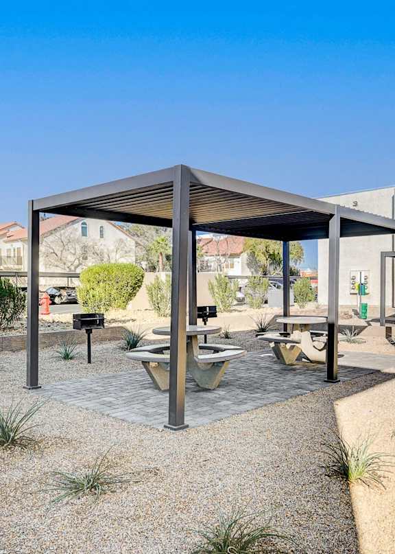 A modern outdoor seating area with a table and chairs under a roof.