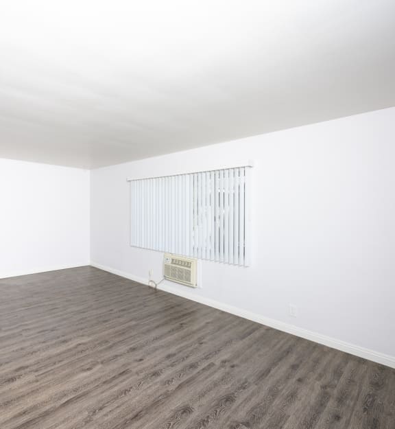 a bedroom with hardwood floors and white walls