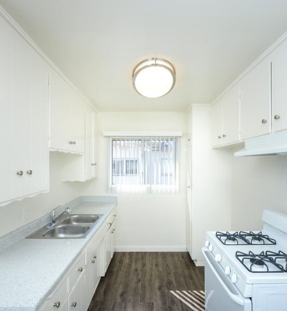 a kitchen with white cabinets and a white stove top oven