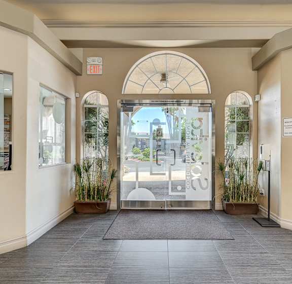 A hallway with a glass door leading to a balcony.