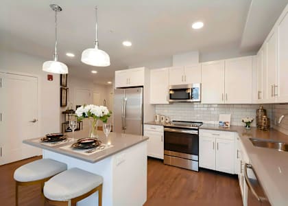 A kitchen with a white countertop and stainless steel appliances.