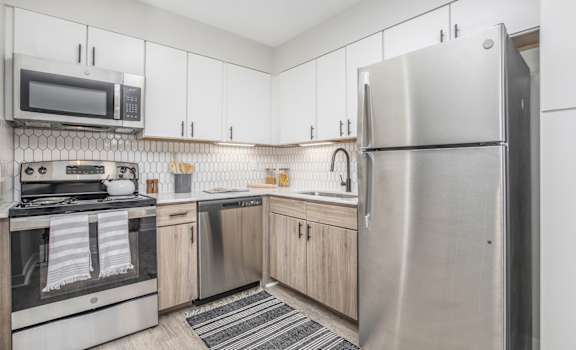 a kitchen with stainless steel appliances and white cabinets