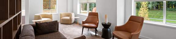 a living room with a couch and chairs and a large window at Hamilton at Eagleview, Pennsylvania